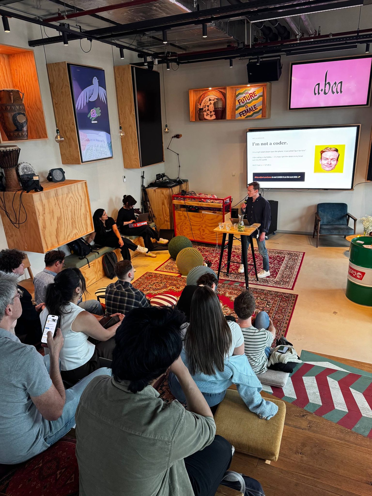 A presenter sharing a project with the audience at the Vibe Coding Open Mic in Amsterdam.